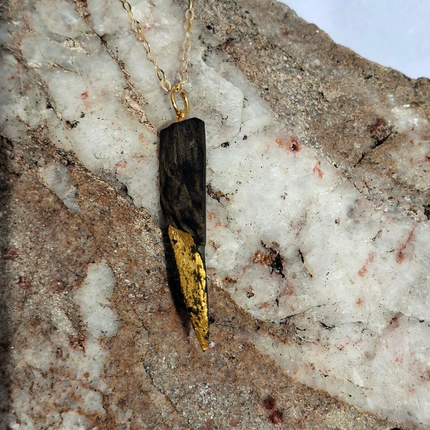 Necklace with a unique pendant on a textured stone surface