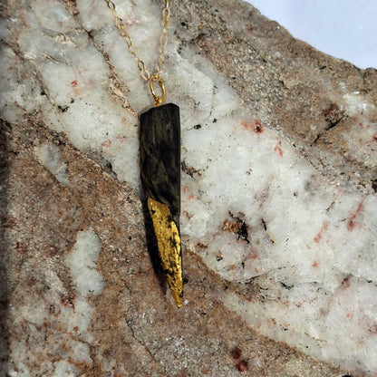 Necklace with a unique pendant on a textured stone surface
